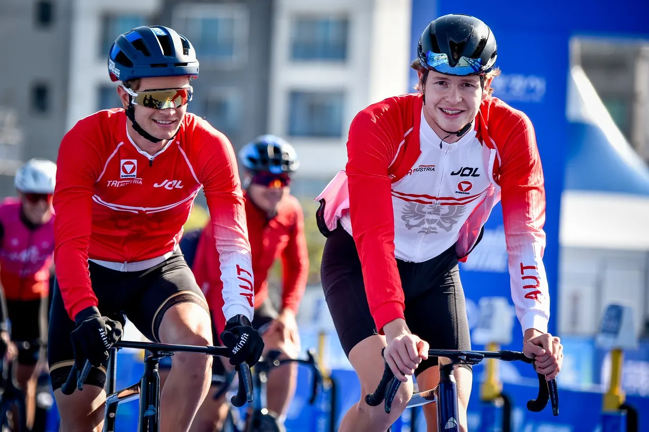 Thomas lachend auf dem Rad im Team-Austria-Trikot